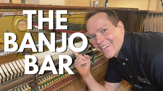 Brigham Larson points to some dampers and strings on the inside of an upright piano. Title reads "The Banjo Bar"